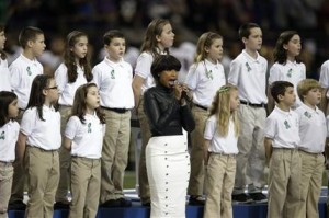 Jennifer Hudson, en el centro, canta "God Bless America" previo al inicio del Super Bowl, acompañada por el coro de la Escuela Primaria Sandy Hook de Newton, Connecticut, el domingo 3 de febrero del 2012 en Nueva Orleáns. (AP Foto/Evan Vucci)