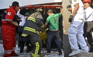 Bomberos pertenecientes al sector Tacubaya y empleados de emergencias rescatan a un sobreviviente después de una explosión registrada en un edificio adyacente a la torre ejecutiva de Pemex, en la Ciudad de México, el jueves 31 de enero de 2013. Las autoridades informaron que la fuerte explosión registrada en los pisos inferiores del edificio dejó decenas de trabajadores heridos. (Foto AP/Guillermo Gutiérrez)