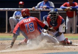 El jugador de Puerto Rico, Irving Falú, es sacado de out en el plato por el catcher de República Dominicana, Carlos Santana, en el Clásico Mundial de Béisbol el sábado, 16 de marzo de 2013, en Miami. (AP Photo/Alan Diaz)