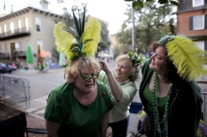 Bev Kehayes, a la izquierda, acompañada de Sara Farnsworth, a la derecha, recibe ayuda de su amiga Mary Parrish, al centro, para ponerse un atavío en la cabeza antes del desfile por el Día de San Patricio en Savannah, Georgia, el sábado 16 de marzo de 2013. El día de San Patricio también es observado con desfiles en Nueva York y Chicago. (AP Foto/Stephen Morton)