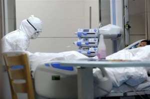 En imagen proporcionada por la agencia estatal de noticias Xinhua, un empleado médico atiende a un paciente de 55 años, que trabajó en una granja avícola y que está infectado con el virus H7N9, de acuerdo con Xinhua, en un hospital de la ciudad de Bozhou, en la provincia Anhui del este de China, el lunes 8 de abril de 2013. Un niño de cuatro años se recupera de una nueva cepa de la gripe aviar que ha causado la muerte de nueve personas en China, informó una médica el miércoles 10 de abril. (Foto AP /Xinhua, Liu Junxi)