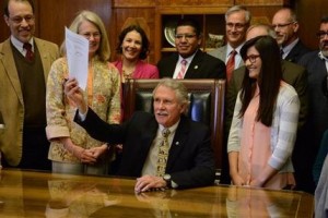 El gobernador de Oregon, John Kitzhaber promulga la iniciativa de ley que otorga a las personas que no tienen los papeles migratorios pertinentes cuotas escolares como si fueran residentes del estado, en el Congreso estatal, el martes 2 de abril de 2013. (Foto AP/Statesman Journal, Danielle Peterson)