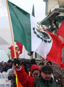 Un manifestante sostiene una bandera de México durante una marcha bajo la nieve desde el Capitolio hacia un parque en Denver, el miércoles 1 de mayo de 2013, para exigir una reforma al sistema que regula la inmigración en Estados Unidos. (Foto AP/Ed Andrieski)