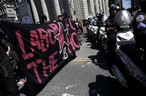 Manifestantes que conmemoran el Día del Trabajo y una reforma migratoria son seguidos por la policía mientras marchan en Nueva York, el miércoles 1 de mayo del 2013. Los activsitas también están piden mejores condiciones de trabajo y otros asuntos. (AP Foto/Seth Wenig)