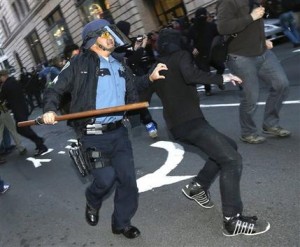 Un policía armado con una porra trata de detener a uno de varios individuos que participaron en una marcha a favor de la inmigración y que les arrojaron piedras, botellas y otros objetos, la noche del miércoles 1 de mayo de 2013 en Seattle. (Foto AP/Ted S. Warren)
