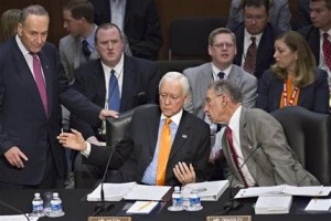 Desde la izquierda, el senador demócrata Chuck Schumer, de pie, y los senadores republicanos Orrin G. Hatch y Chuck Grassley, dialogan en la reunión del Comité Judicial sobre la reforma migratoria en el Capitolio en Washington, el jueves 9 de mayo de 2013. (AP foto/J. Scott Applewhite)