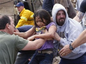 Un niña es sacado de los escombros que quedaron de la escuela primaria Plaza Towers en Moore, Oklahoma, tras el paso de un enorme tornado, el lunes 20 de mayo de 2013. El tornado de 1,6 kilómetros (una milla) de ancho con vientos de 320 kph (200 mph) destruyó decenas de suburbios en Oklahoma City. (Foto AP/Sue Ogrocki)