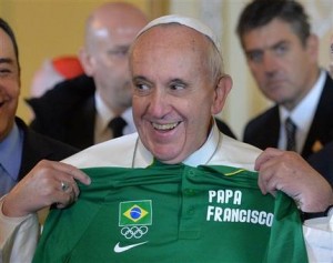 El papa Francisco con una camiseta olímpica con su nombre que le entregaron en Río de Janeiro, Brasil, el jueves 25 de julio de 2013. El pontífice bendijo la bandera olímpica, visitó una favela y se dirigirá a miles de jóvenes católicos en la playa de Copacaba el mismo jueves. La camiseta se la entregó Carlos Arthur Nuzman, presidente del Comité Olímpico de Brasil. (Foto AP/Luca Zennaro, Pool)