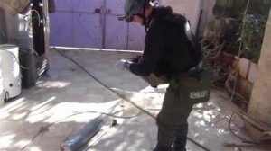 En esta imagen tomada de un video amateur publicado en internet, un presunto miembro del equipo de investigación de la ONU mide y fotografía una lata en el suburbio de Moadamiyeh en Damasco, Siria, el lunes 26 de agosto de 2013, en donde presuntamente hubo un ataque con armas químicas. AP no pudo verificar la autenticidad del video, pero concuerda con los informes de Associated Press. (Foto AP/MEDIA OFFICE OF MOADAMIYEH) TV OUT