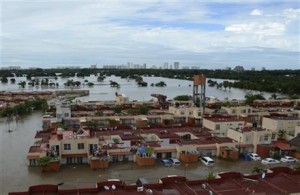 Vecindarios enteros inundados y personas paradas en los techos de las casas después de que la tormenta tropical Manuel golpeara el famoso Puerto turístico de Acapulco, México, el martes 17 de septiembre de 2013. Cientos de turistas han resultado damnificados a la vez y hoy buscan los medios para salir del famoso balneario. (AP/ Bernandino Hernandez)