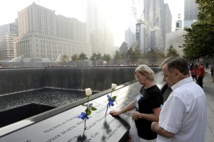 Una pareja hace una pausa al borde de la Piscina Norte en el monumento a las victimas del 11 de Septiembre, durante los homenajes para conmemorar el aniversario número 12 de los ataques terroristas al World Trade Center en Nueva York. (Reuters)
