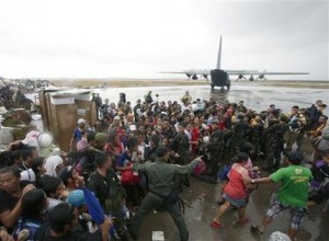 Sobrevivientes del tifón tratan de abordar un avión militar de transporte C-130 en la ciudad de Tacloban, provincia de Leyte, Filipinas, el martes 12 de noviembre de 2013. (Foto AP/Bullit Marquez)