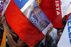 Partidarios de la candidata presidencial y ex presidenta Michelle Bachelet hacen ondear banderas durante un mitin de victoria en Santiago, Chile, el domingo 15 de diciembre de 2013. Con 90% de los votos escrutados, Bachelet tenía una ventaja abrumadora de 62% contra 38% sobre la candidata centroderechista Evelyn Matthei, quien ya reconoció la derrota. (Foto AP/Luis Hidalgo).