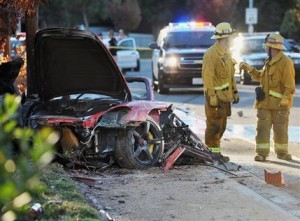 Agentes trabajan cerca de los escombros de un Porsche que se estrelló contra un poste de luz en la calle Hércules cerca de la autopista Kelly Johnson en Valencia, California, el sábado 30 de noviembre del 2013. El astro de "Fast & Furious" Paul Walker, quien viajaba como pasajero en el auto, murió en el accidente. Tenía 40 años. (AP Foto/The Santa Clarita Valley Signal, Dan Watson)
