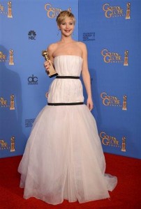Jennifer Lawrence, eligió un vestido blanco y escotado de Dior que complementó con aretes largos y con esmeraldas.