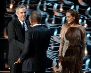 Angelina Jolie, derecha, y Sidney Poitier entregan el Oscar al mejor director a Alfonso Cuarón por "Gravity" en los Oscar en el Teatro Dolby el domingo 2 de marzo de 2014 en Los Angeles. (Foto John Shearer/Invision/AP)