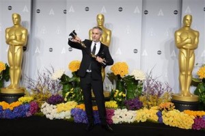 El cineasta mexicano Alfonso Cuarón posa en la sala de prensa con sus dos Oscar, a mejor director y edición por su trabajo en "Gravity", el domingo 2 de marzo del 2014 en Los Angeles. (Foto por Jordan Strauss/Invision/AP)