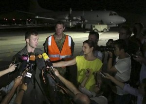 El capitán piloto Russell Adams de la Real Fuerza Aérea Australiana, izquierda, habla con reporteros después de regresar de una misión de búsqueda del avión malasio desaparecido, el domingo 23 de marzo de 2014, en la Base Pearce, en Perth, Australia. (Foto AP/Matt Jelonek, Pool)