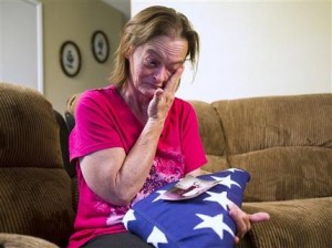 Vicky Olson se limpia las lágrimas mientras conversa el 9 de mayo de 2014 sobre la muerte de su esposo, Michael Olson, ex militar de la marina, en la cochera de la casa de ambos en Phoenix, Arizona. Pesan acusaciones de negligencia sobre el servicio médico de los veteranos de guerra en Estados Unidos. (AP Foto/The Arizona Republic, Tom Tingle)