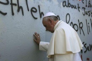 El Papa Francisco toca el muro que divide Israel de Cisjordania en su camino a una misa en la Plaza del Pesebre, cerca de la Iglesia de la Natividad en Belén. Belén, 25 de mayo de 2014. REUTERS/Mheisen Amareen.