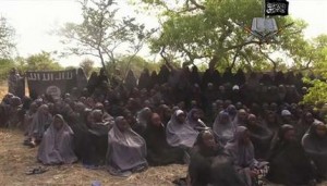 Esta foto tomada de un video de la red terrorista nigeriana Boko Haram, lunes 12 de mayo de 2014, muestra supuestamente a las niñas secuestradas de la población de Chibok en el noreste de Nigeria. El nuevo video presuntamente muestra a decenas de las niñas secuestradas, cubiertas con el hijab y rezando en árabe. (AP Foto)