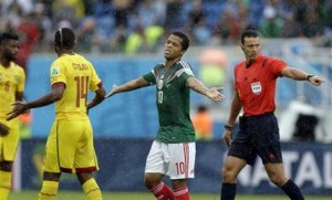 El jugador de México, Giovani Dos Santos, centro, gesticula después de una decisión del árbitro en un partido contra Camerún por la Copa del Mundo el viernes, 13 de junio de 2014, en Natal. (AP Photo/Ricardo Mazalan)