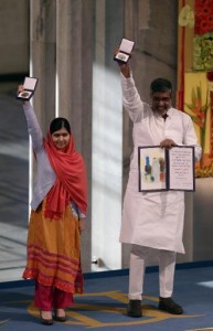 Los galardonados con el Premio Nobel de la Paz Kailash Satyarthi (dcha) y Malala Yusafzai sujetan sus medallas durante la ceremonia de entrega de los premios en el ayuntamiento de Oslo, el 10 de diciembre de 2014 (AFP | Vegard Wivestad Grott)