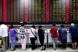 Investors look at computer screens showing stock information at a brokerage house in Shanghai, China, July 8, 2015.  REUTERS/Aly Song