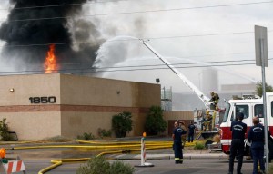 Personal del cuerpo de bomberos de Phoenix, tratan de apagar las llamas de un intenso incendio que se produjo en una compañía de reciclaje de solventes al sur del centro de Phoenix, Arizona, el miércoles 9 de septiembre de 2015. (Foto de Rob Schumacher/The Arizona Republic vía AP)