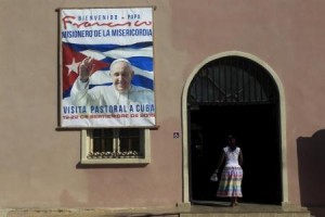 Una mujer entra en una iglesia que tiene un cartel que anuncia la visita del Papa Francisco a Cuba, en Santiago de las Vegas, Cuba, 8 de septiembre de 2015. Cuba anunció el viernes que indultará a 3.522 prisioneros en los próximos tres días de cara a la visita que realizará el Papa Francisco a la isla entre el 19 y el 22 de septiembre, reiterando una acción similar llevada a cabo antes de un viaje de Benedicto XVI a La Habana en el 2012. REUTERS/ Stringer