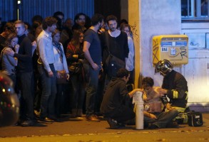 A member of the French fire brigade aids an injured individual near the Bataclan concert hall following fatal shootings in Paris, France, November 13, 2015. REUTERS/Christian Hartmann