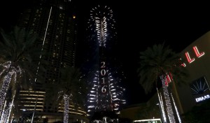 Fireworks explode over Dubai's Burj Khalifa, the tallest building in the world, during the New Year celebrations January 1, 2016, as the Address Downtown Dubai hotel and residential block, which had been engulfed by a fire, can be seen on the left. REUTERS/Ahmed Jadallah