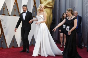 Lady Gaga de blanco en un diseño de su estilista Brandon Maxwell, en su llegada a la alfombra roja del brazo de su novio Taylor Kinney. REUTERS/Lucy Nicholson