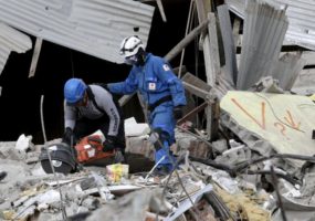 Red Cross members cut an iron rod at a collapsed building as they search for victims in Pedernales, after an earthquake struck off Ecuador's Pacific coast, April 20, 2016. REUTERS/Henry Romero