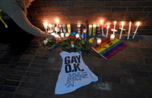 A woman places a candle at a make-shift memorial for the victims of the mass shooting at Orlando's Pulse nightclub, in Boston June 13, 2016. REUTERS/Gretchen Ertl