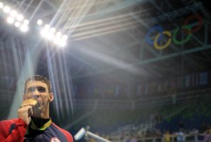 Michael Phelps poses with his gold medal. REUTERS/Dominic Ebenbichler