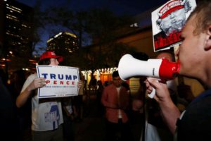 Protesters face off with a supporter of Donald Trump outside the Phoenix Convention Center as the candidate gives a speech on immigration in Phoenix, Arizona. REUTERS/Nancy Wiechec