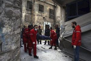 En esta imagen, tomada el 7 de diciembre de 2016 y distribuida por Cruz Roja Internacional, miembros de la Media Luna Roja cargan con un paciente en una camilla en el exterior de un centro sanitario en la Ciudad Vieja de Aleppo, en Siria. (Media Luna Roja Siria/Noor Hazouri via AP)